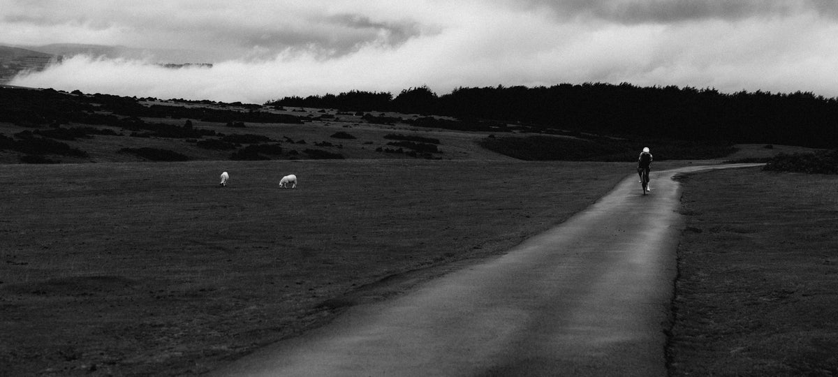 A lone rider on a Pearson Forge on an open moorland road under heavy cloud