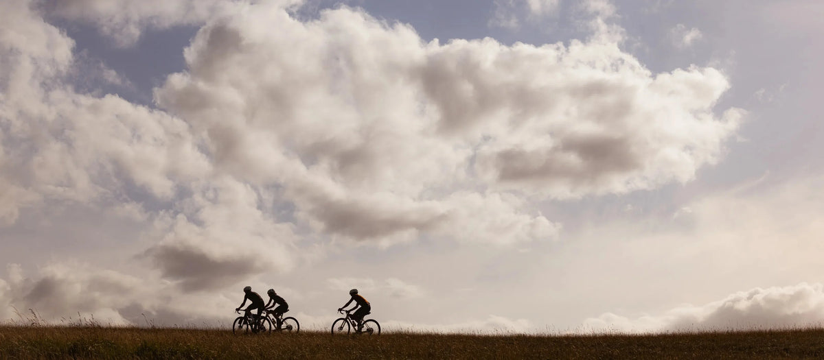 Gravel riders silhouetted on a ridgeline under open sky on Pearson On&On Adventure bikes